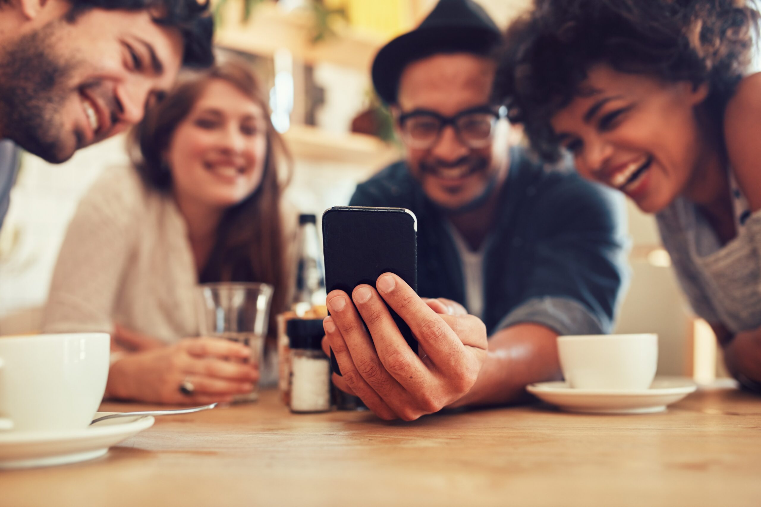 Eine Gruppe von Freunden lesen auf einem Smartphone Fakten über die englische Sprache