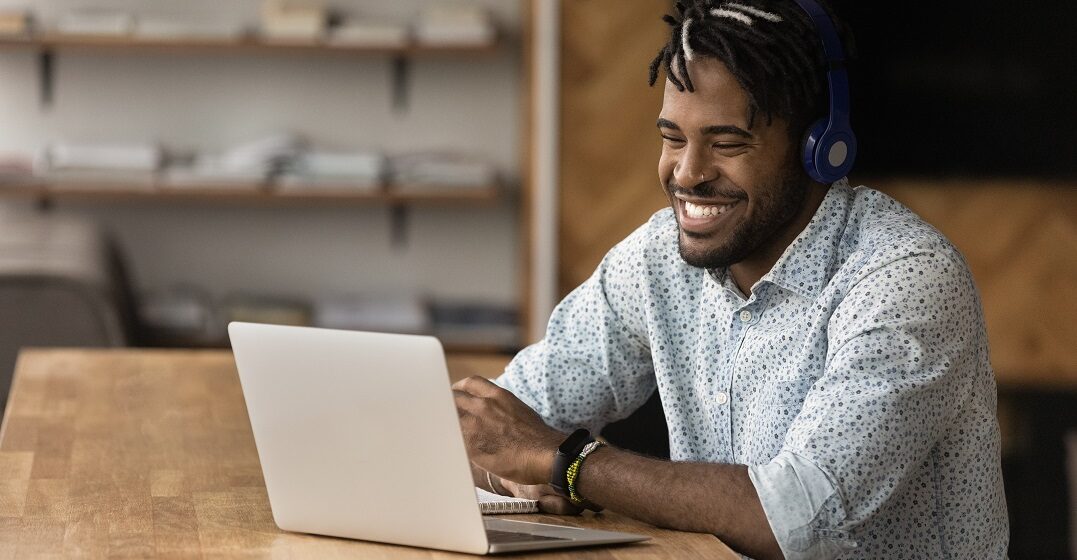 Man at his laptop laughing while learning 10 funny german words