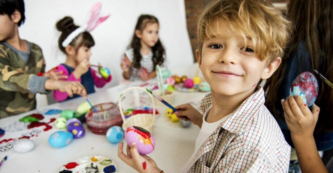 Little boy painting an easter egg as part of the Easter traditions