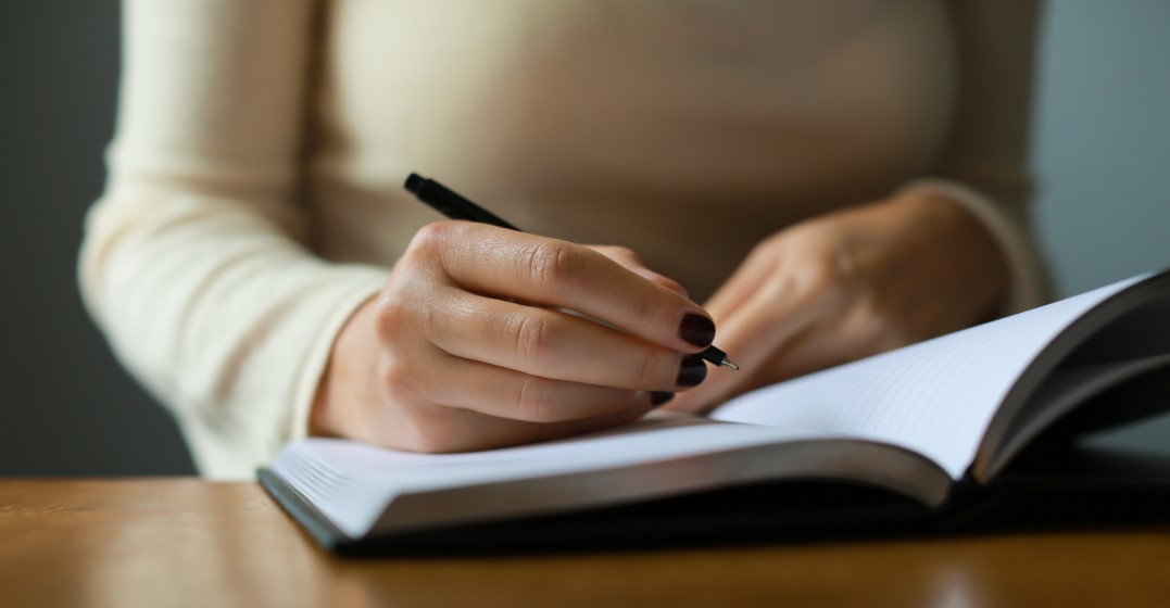woman writing down her language learning goal for the year in her diary