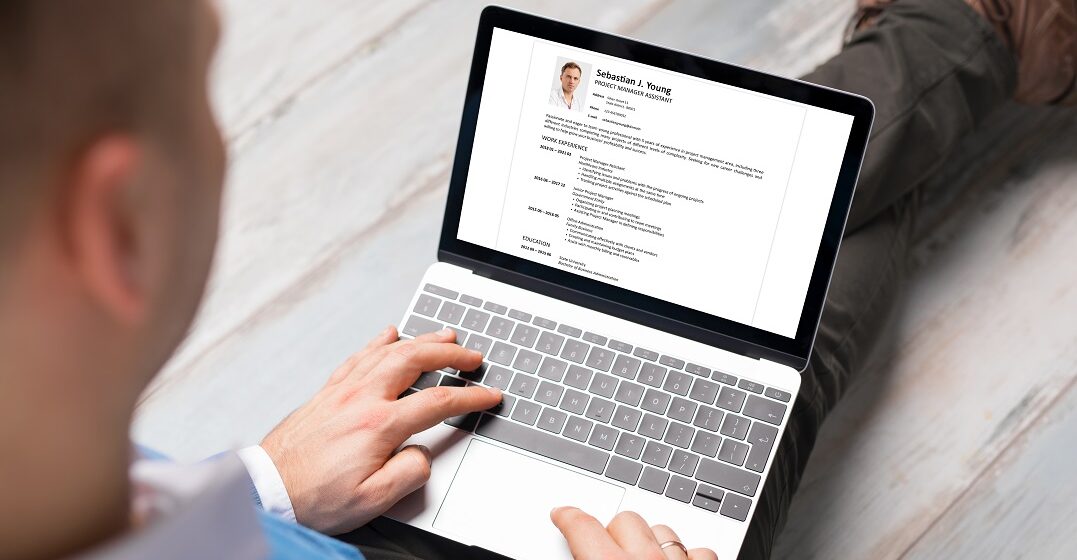 Man learning how to write a cv in English on his laptop