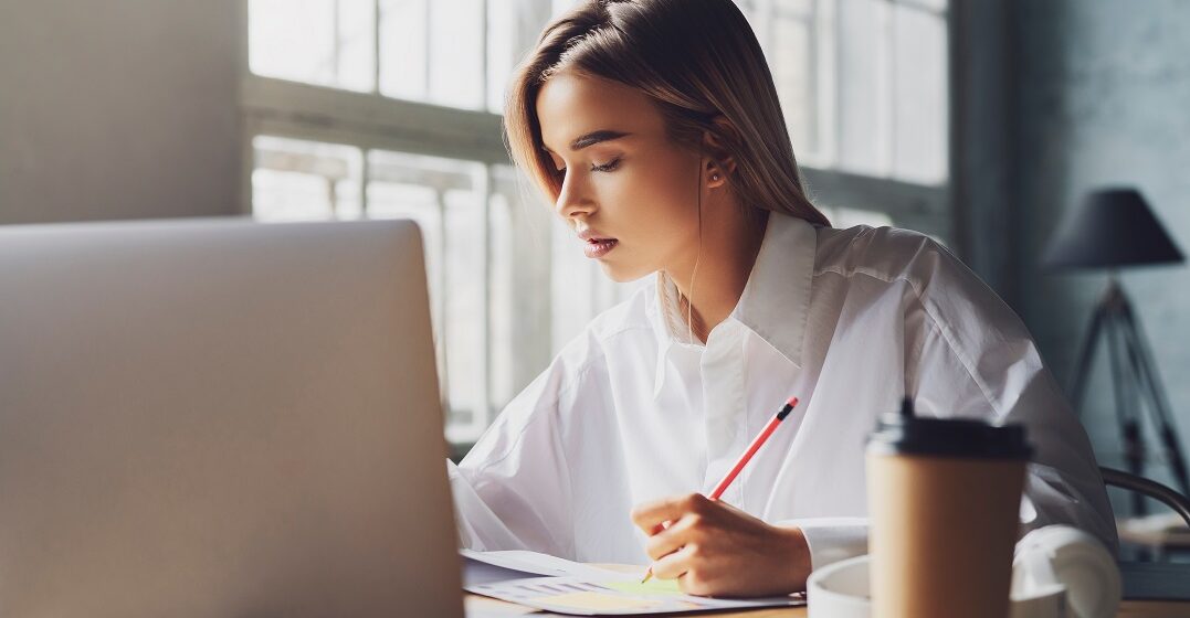 Girl,Sitting,Concentrated,At,Laptop,And,Studying,Remotely.,Student,Using laptop and learning useful phrases in English