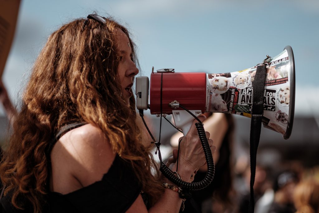 woman speaking confidently through megaphone 