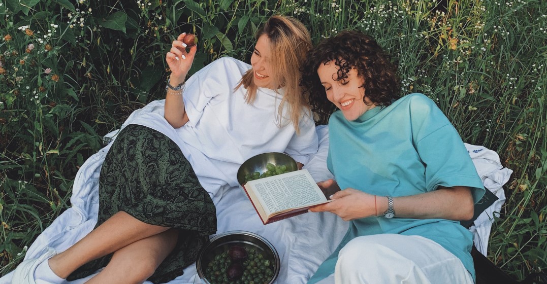 Two friends on a picnic blanket wondering about what languages are spoken in Germany