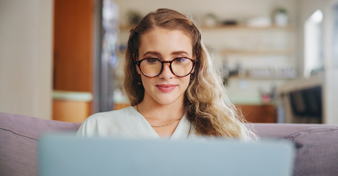 Eine Frau an ihrem Laptop recherchiert englische Nachrichtenseiten