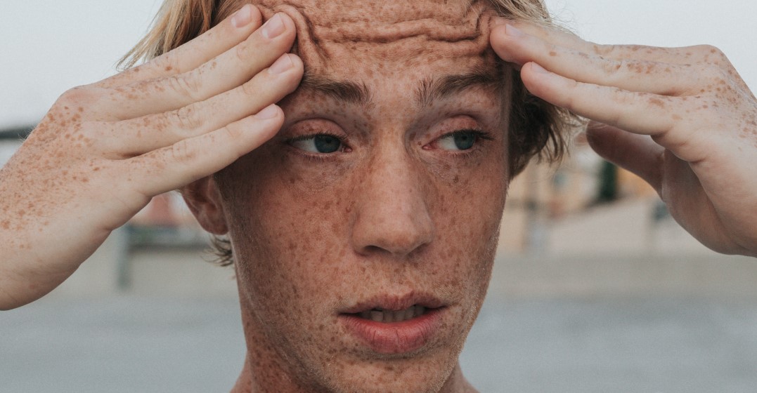 Worried looking man with freckles wondering about Englsih phrases that don't make sense