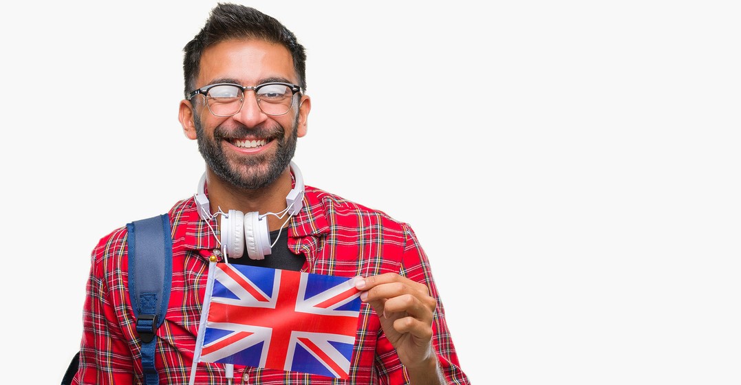 Ein Mann mit britischer Flagge lächelt über typsisch britische Wörter