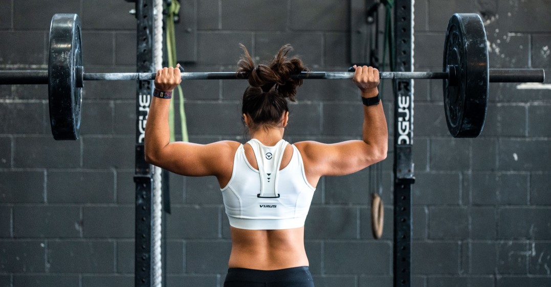 woman lifting heavy weights and thinking of popular sports idioms