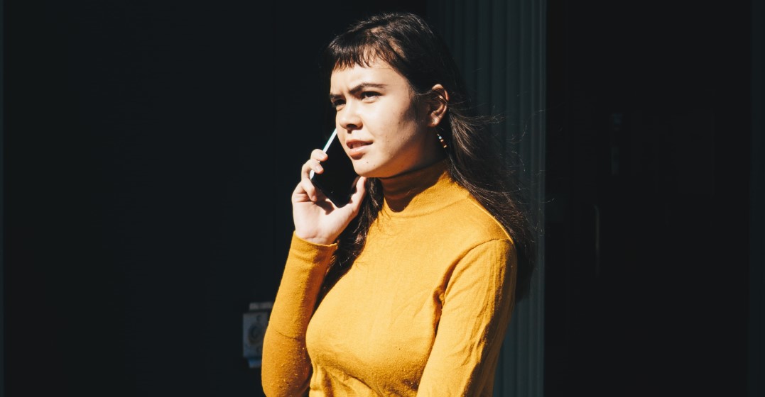 A woman with a worried facial expression is calling an emergency number in Germany