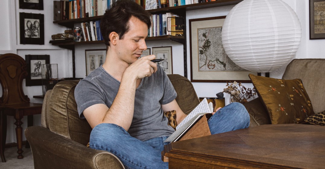 Young man in an armchair studying English modal verbs