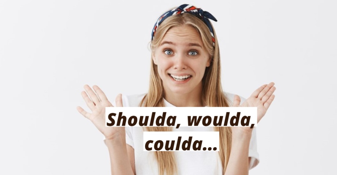 Close-up of a young woman with raised hands expressing regret in English
