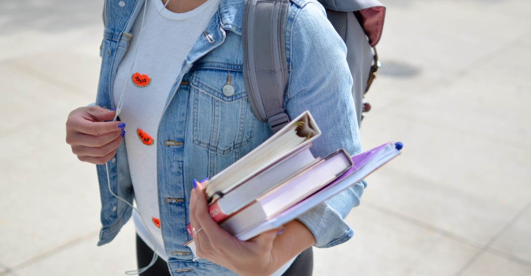 A student holding books and going to one of the best universities in Germany for overseas students