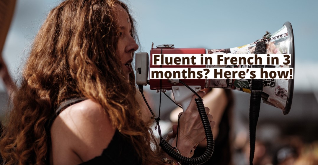 A woman with a megaphone. A banner on the megaphone saying 