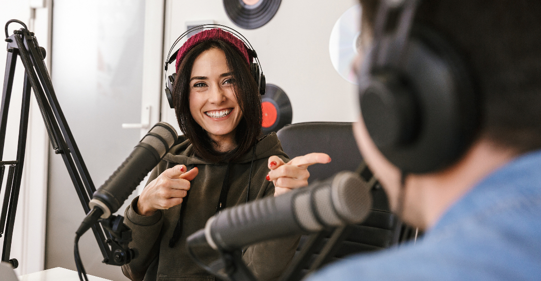 Smiling woman listening to podcasts to learn English