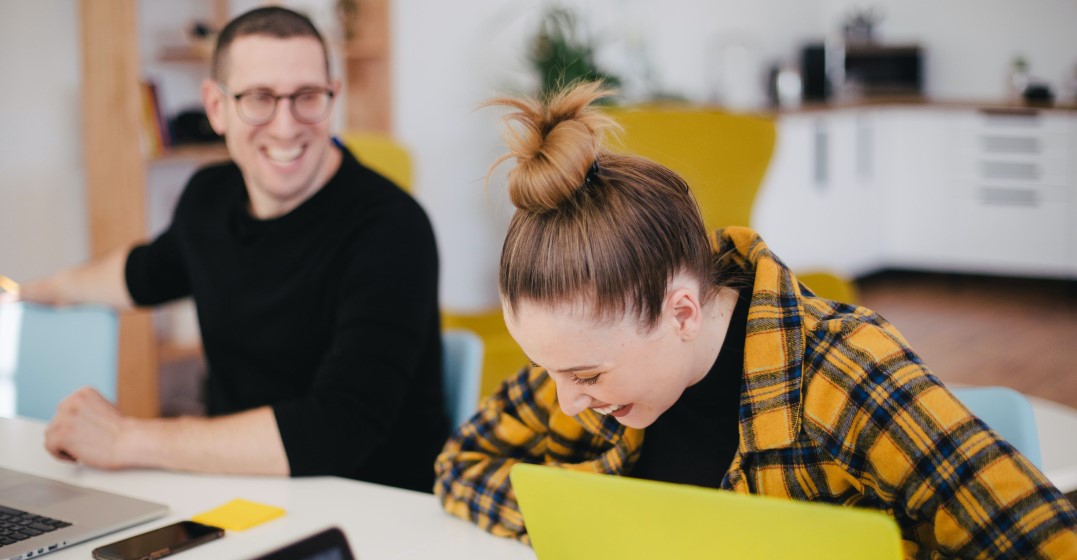 Two smiling students discussing if they need to peak Germany to work in Germany