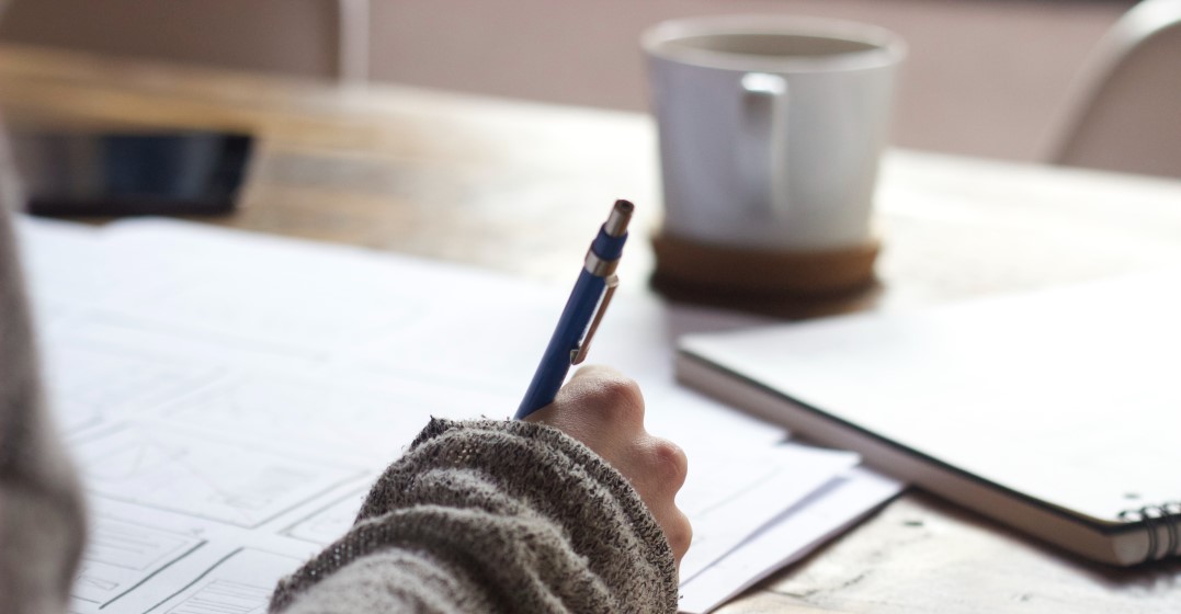 Woman writing down on her note book 8 tips on how to learn a new language