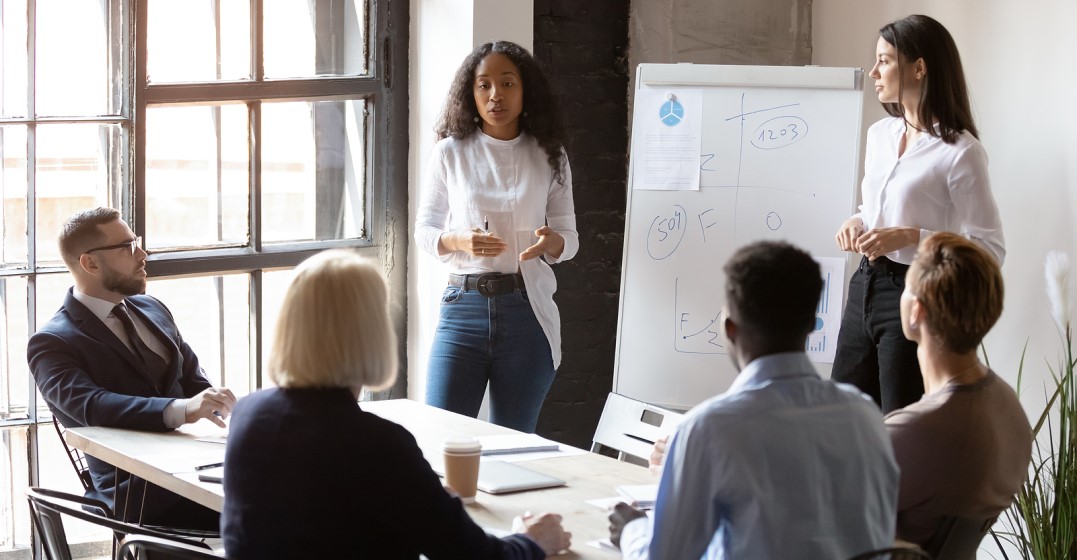 Woman next to a flip chart giving a presentation in English for 2 people