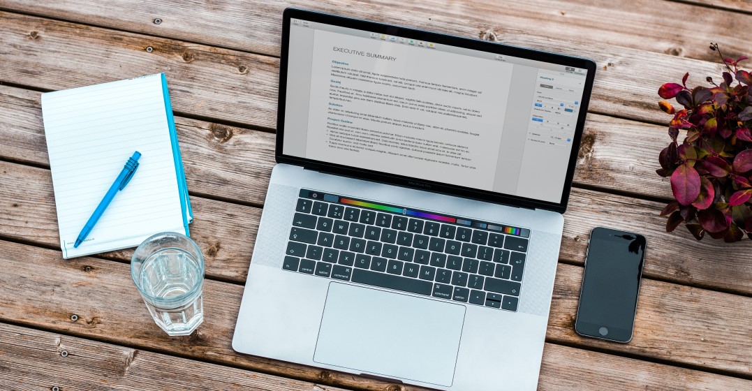 set up of a laptop notebook and pen and water reading to write an american style resume
