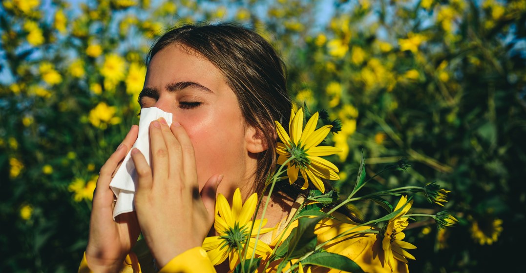 woman sneezing because she has allergies