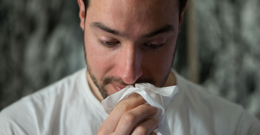man sneezing as he has allergies