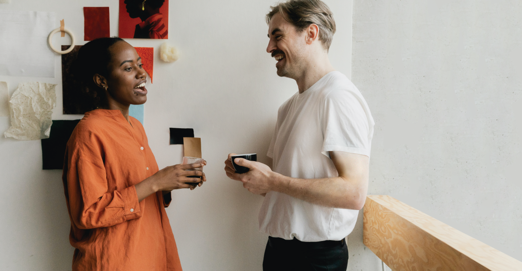 man and woman talking after the man has sneezed and the woman has said gesundheit