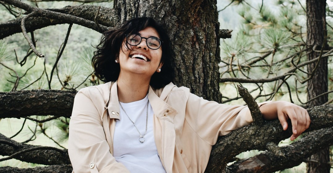 woman laughing because she is thinking about learning a language for her new year's resolution