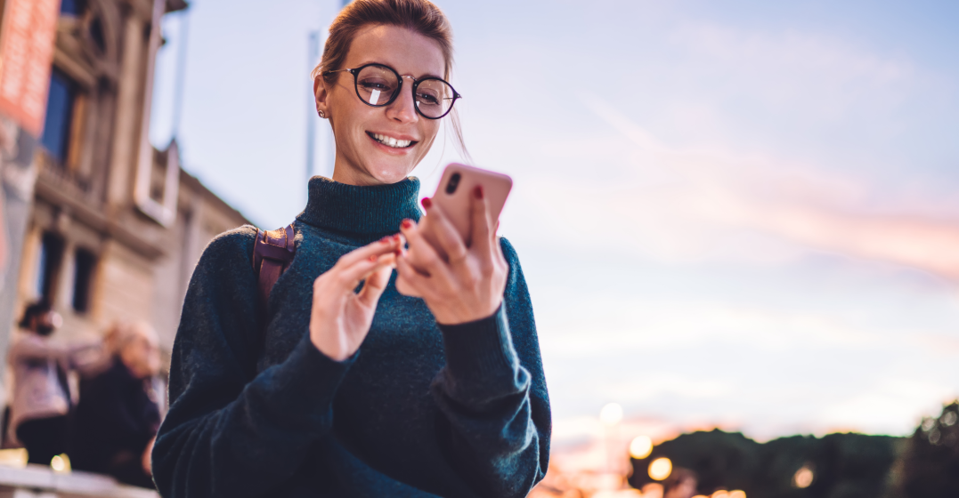 woman using her phone to look up self-care information in spanish