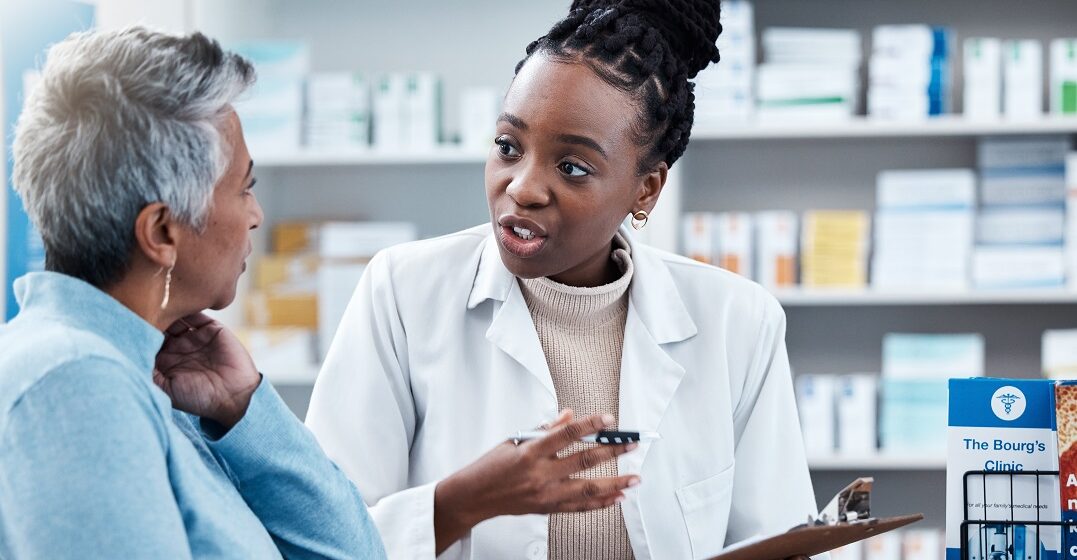 A Spanish pharmacist listening to a customer