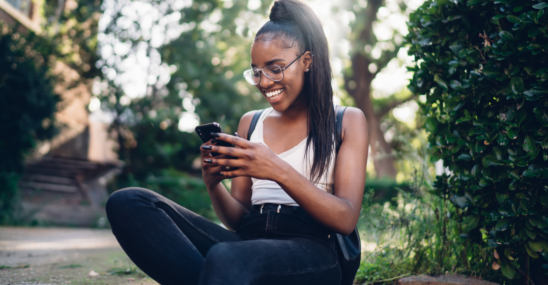 a German woman smiling at her phone at she plans how to spend Valentine's Day