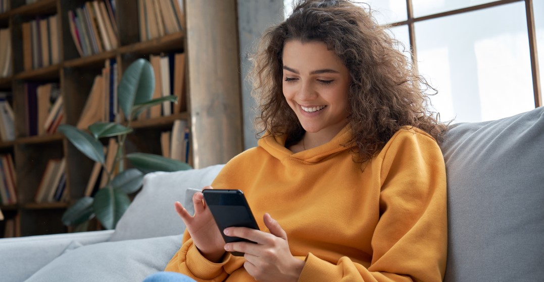 Woman watching the best TikTok accounts for learning English on her phone