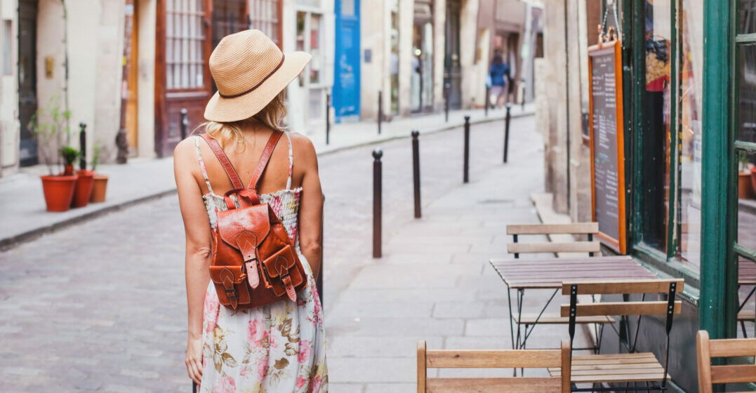 woman tourist walking on the street shown from the back