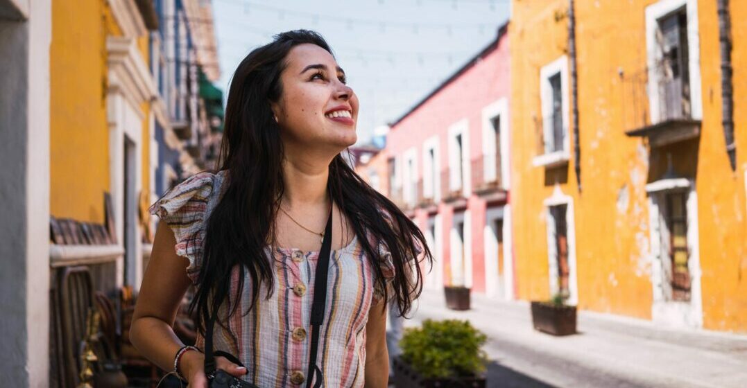 Smiling woman in a street with colorful houses