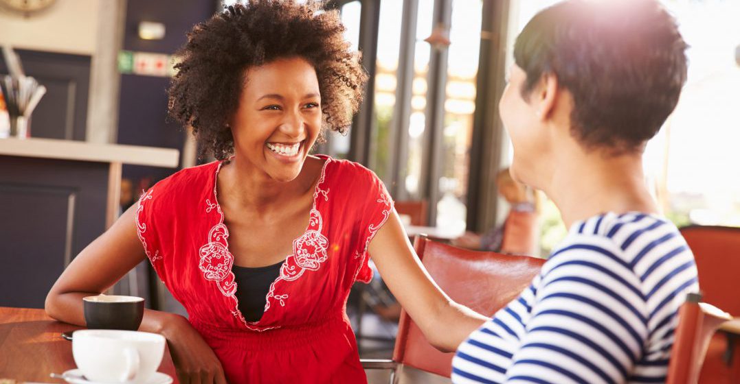 Two female friends talking at a coffee shop