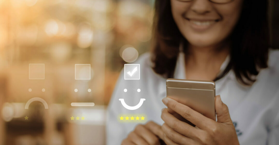 Smiling woman holding her smartphone, review icons in the background