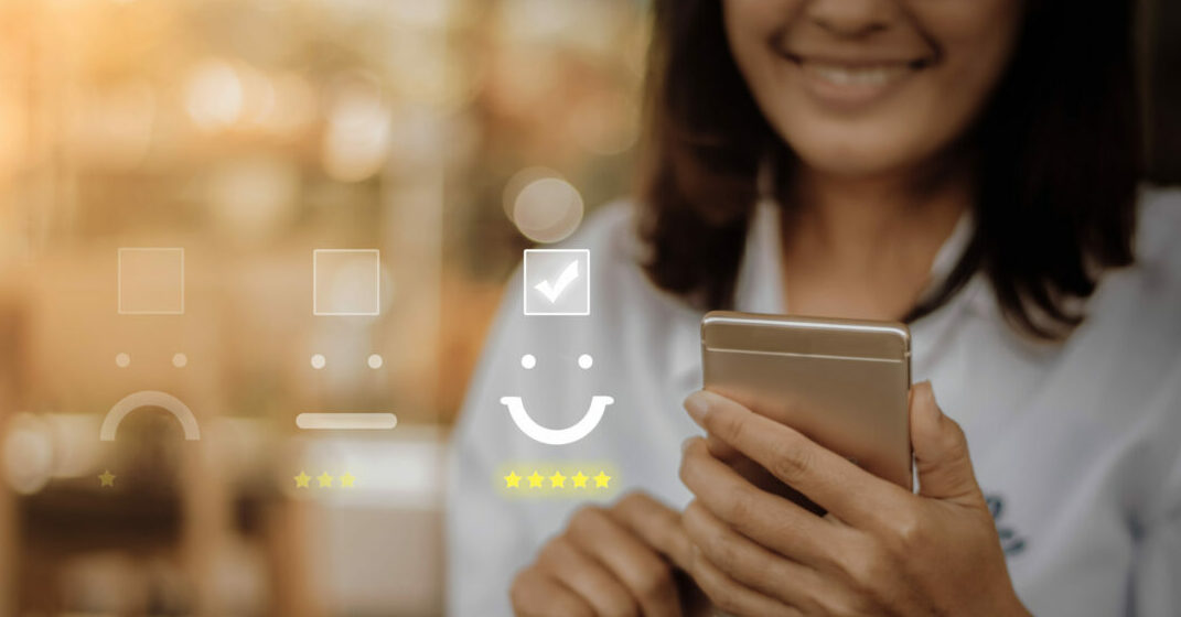 Woman holding a smartphone smiling, review icons in the background