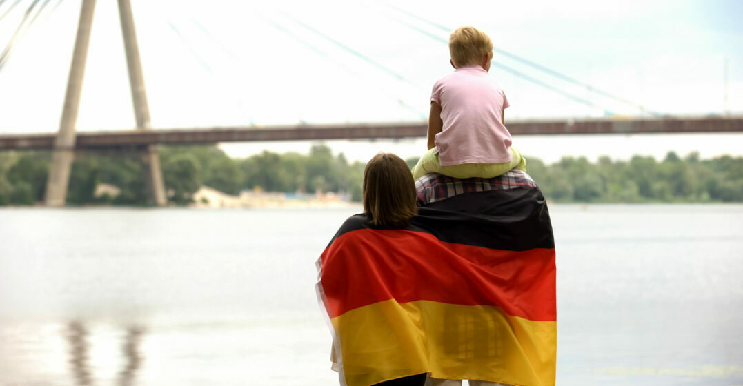 Family wrapped in German flag looking at bridge