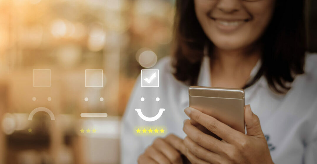 Lächelnde Frau am Smartphone, Bewertungs-Icons im Hintergrund