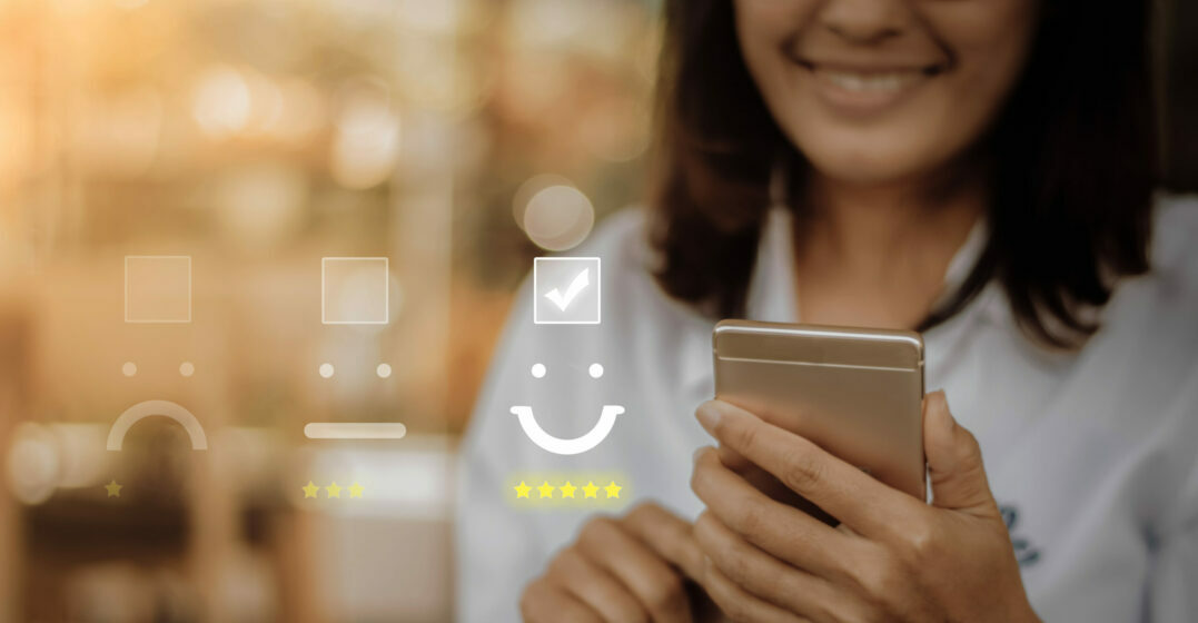 SMiling woman holding a phone, review icons in the background