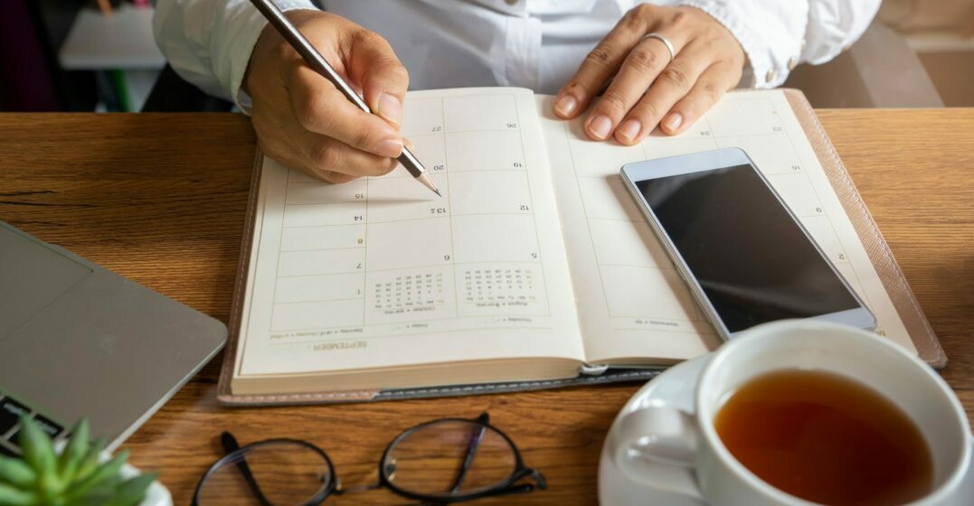 Un cahier ouvert et un portable d'une personne qui apprend comment écrire la date en agnlais