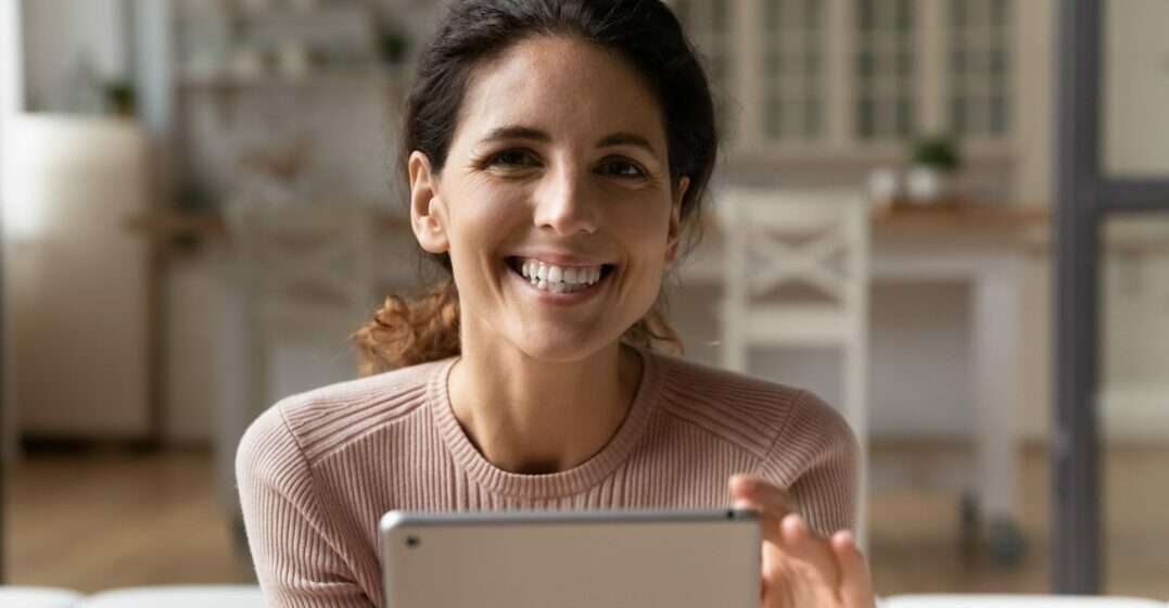 Une femma avec un iPad qui lit sur les avantages Lingoda