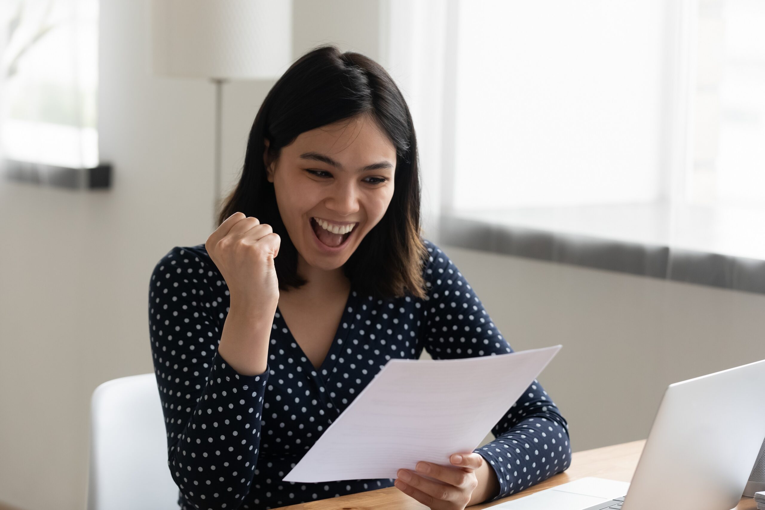 Mujer feliz con un certificado MCER de Lingoda en la mano