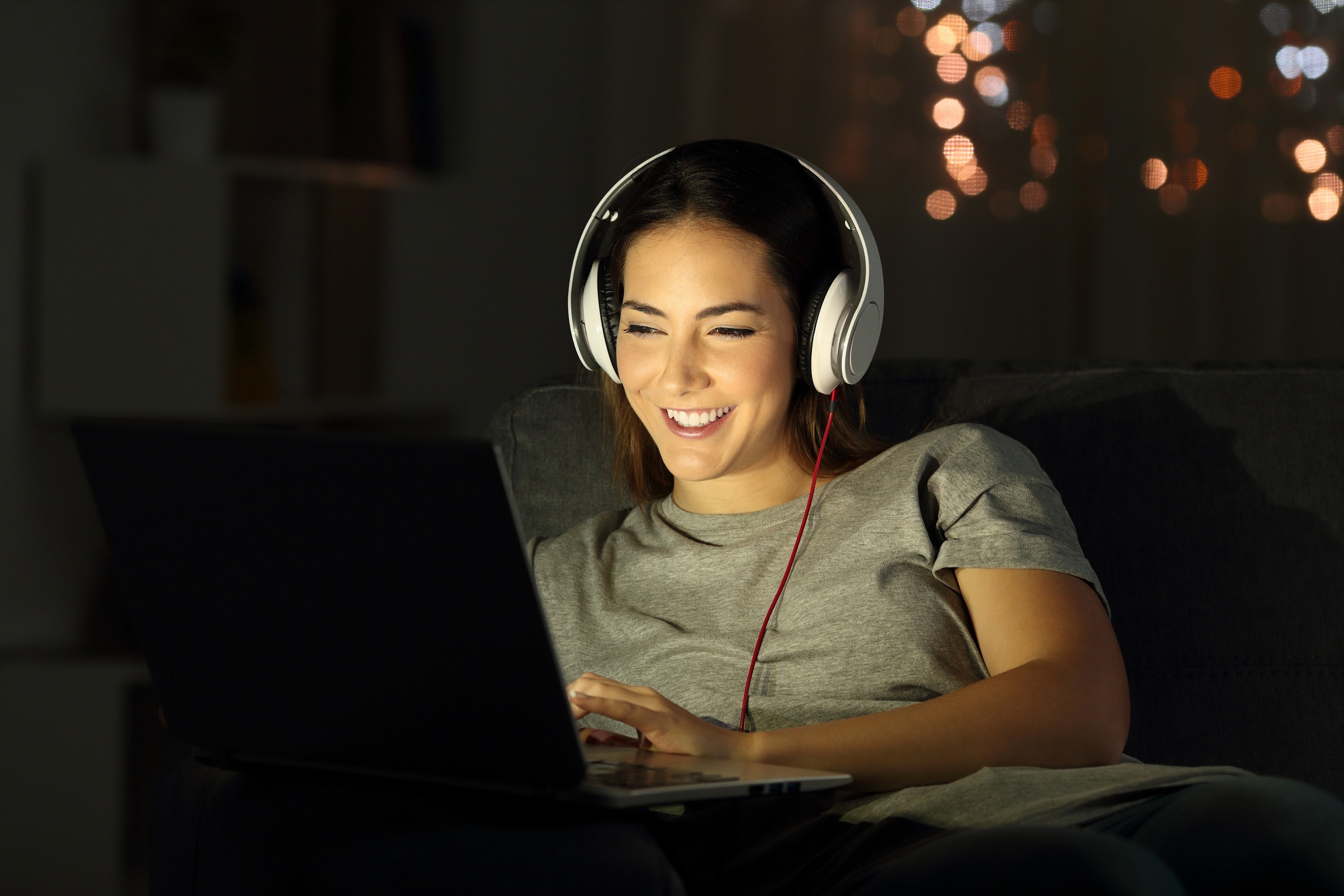 Une femme regarde un film sur son ordinateur portable et utilise des adjectifs anglais pour décrire un film