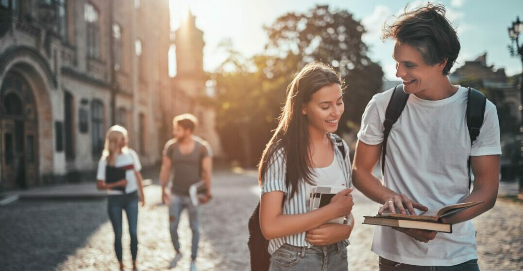 Two students on a campus talking about the requirements to study in Europe
