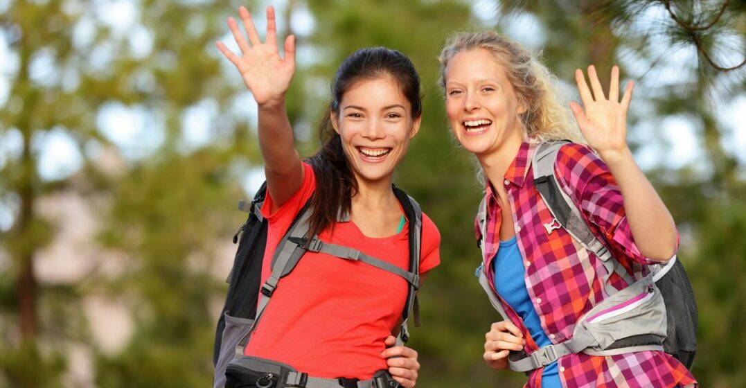 Two girls waving and saying bye in German