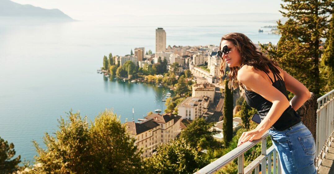 A young womand in front of a Swiss lake exploring the cantons of Switzerland