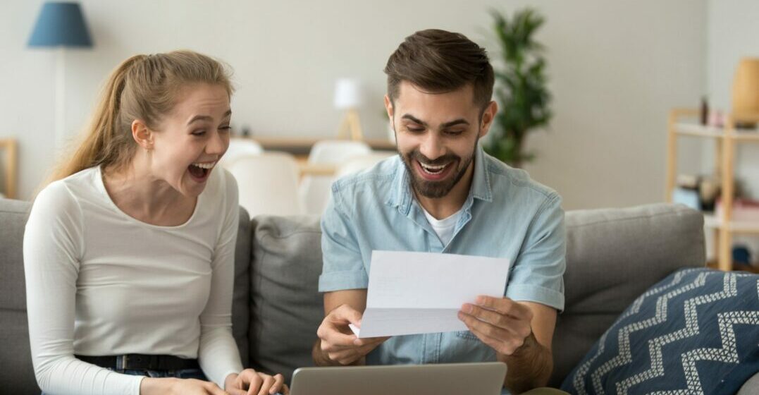 A man and a woman with a paper in their hands are happy about how to file a tax return in Germany