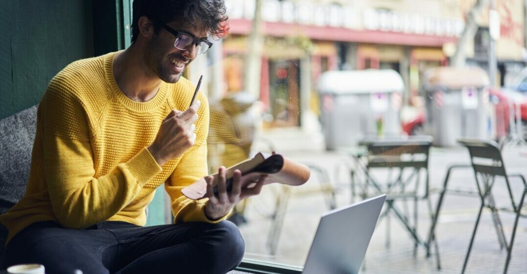 A young an in front of a laptop studying the Present Tense in Spanish