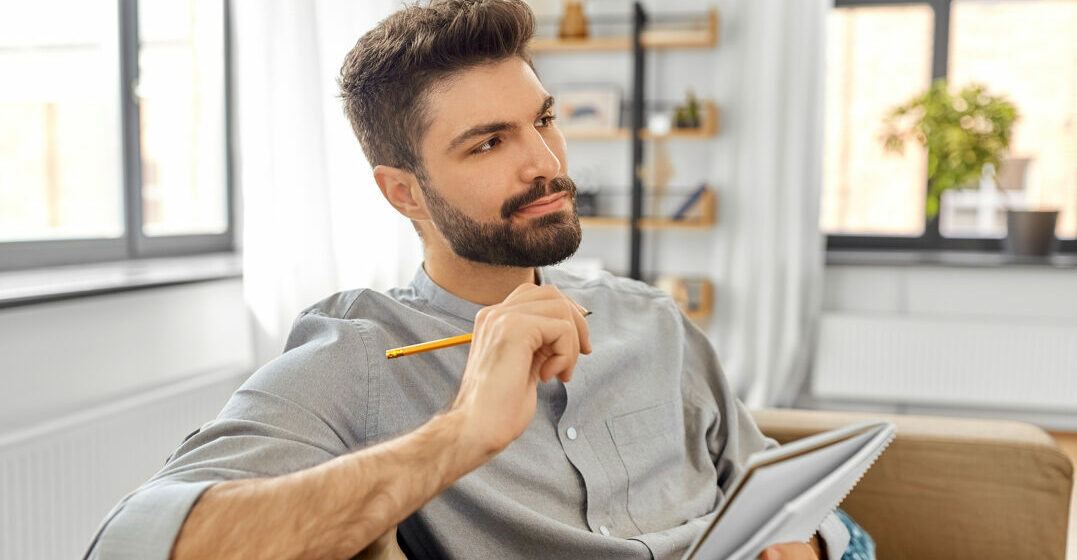 Man trying to write the hardest english words to spell