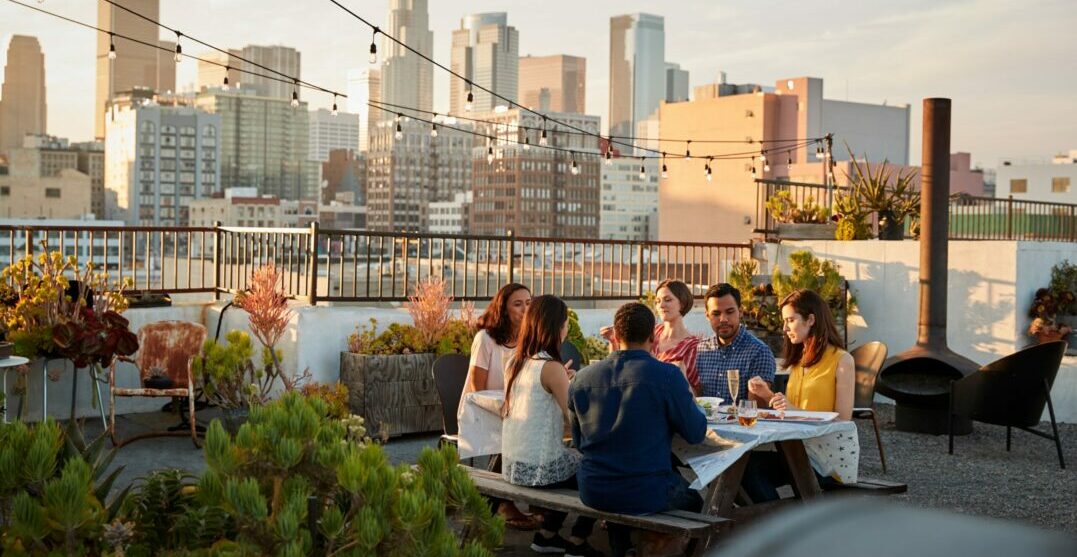 Amigos en una mesa frente al horizonte hablando de cosas que hacer en Los Ángeles