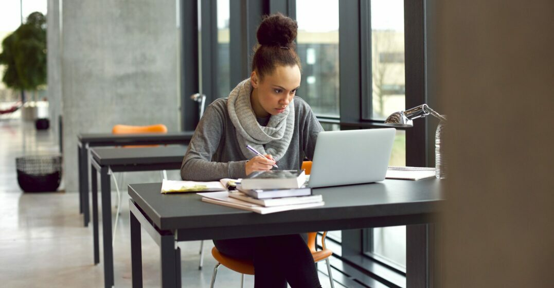 Young woman at a study table reading about the use of have or has
